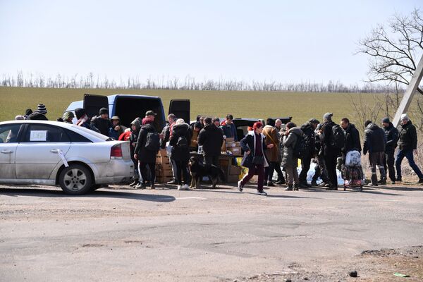 На фото: беженцы из Мариуполя в пункте раздачи еды, которые организовали волонтеры из Донецка. - Sputnik Литва