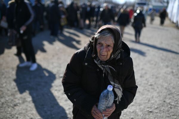 На фото: пожилая беженка из Мариуполя в пункте временного размещения в селе Безыменное. - Sputnik Литва