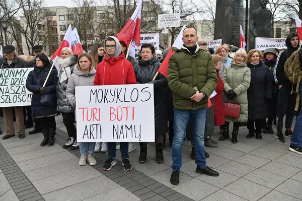 Akcijos dalyvis laiko plakatą su užrašu: &quot;Mokyklos turi būti arti namų&quot;. - Sputnik Lietuva