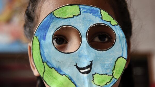 Ученик надевает маску, сделанную в форме планеты Земля, во время мероприятия по случаю Дня Земли в школе в Амритсаре, Индия - Sputnik Lietuva