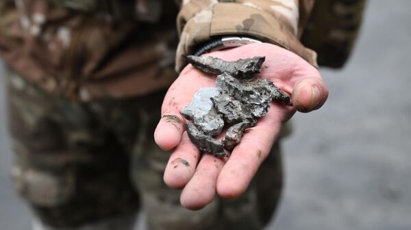 Военнослужащий демонстрирует осколки боеприпасов, архивное фото - Sputnik Литва