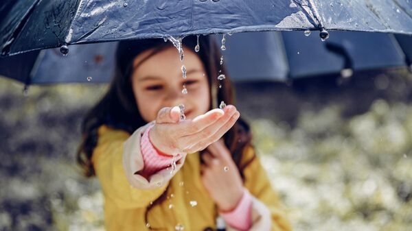 Девочка держит зонтик и ловит капли дождя, архивное фото - Sputnik Литва