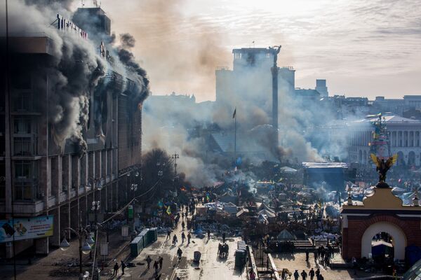 На фото: дым от пожаров и сторонники оппозиции на площади Независимости в Киеве. - Sputnik Литва