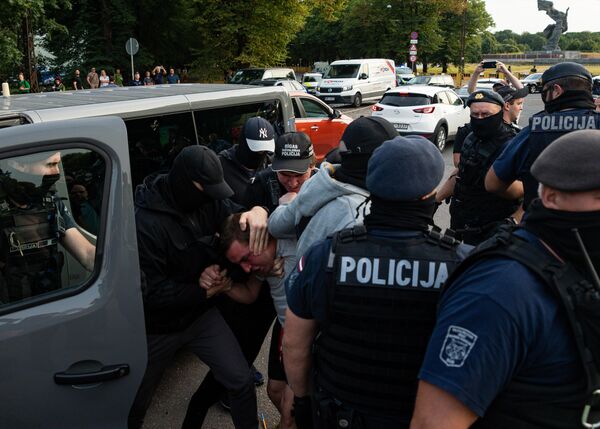 На фото: сотрудники полиции забирают одного из участников акции против сноса памятника советским воинам. - Sputnik Литва