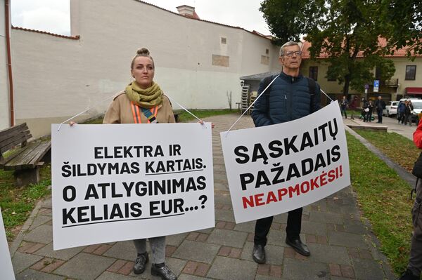 Участники акции протеста держат плакаты с надписями: &quot;Электричество и отопление в разы, а зарплата на несколько евро?&quot;, &quot;Обещаниями счета не оплатишь!&quot; - Sputnik Литва