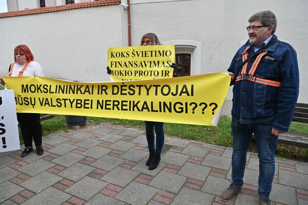 Участники акции протеста держат плакат с надписью: &quot;Ученые и преподаватели нашему государству не нужны?&quot; - Sputnik Литва
