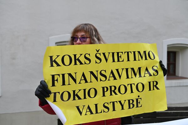 Участница акции протеста держит плакат с надписью: &quot;Какое финансирование образования, такого ума и государство&quot;. - Sputnik Литва