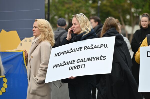 На фото: участница акции протеста в Вильнюсе с плакатом, на котором написано &quot;Не просим пособий, просим о возможности работать&quot;. - Sputnik Литва
