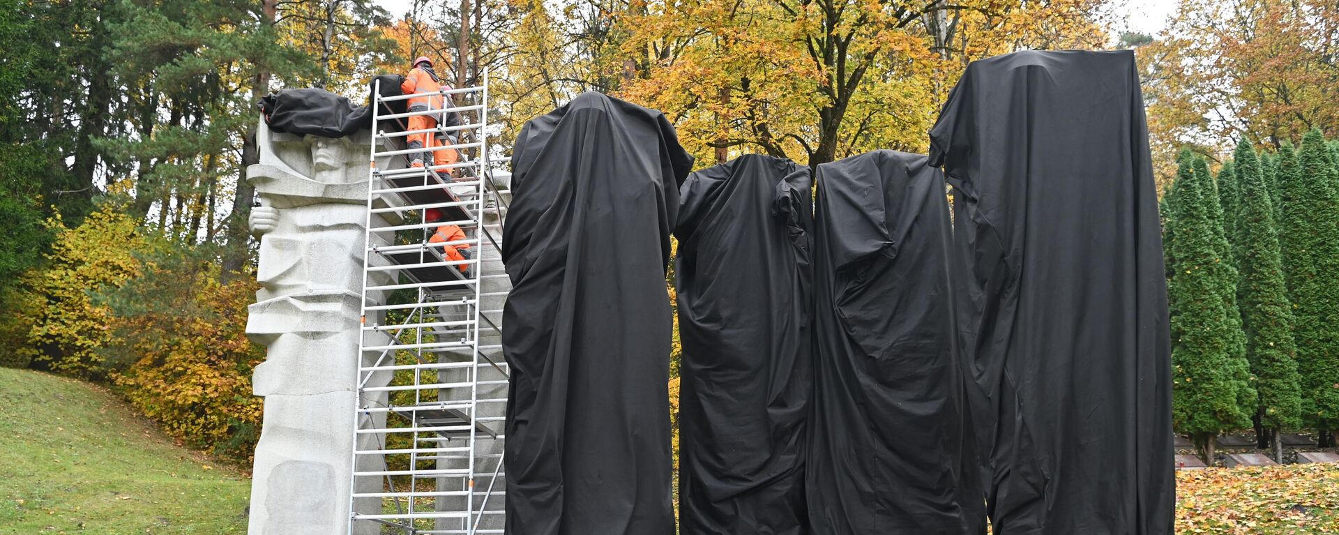 Рабочие закрывают черной тканью памятник советским воинам на Антакальнисском кладбище в Вильнюсе - Sputnik Литва, 1920, 13.10.2022