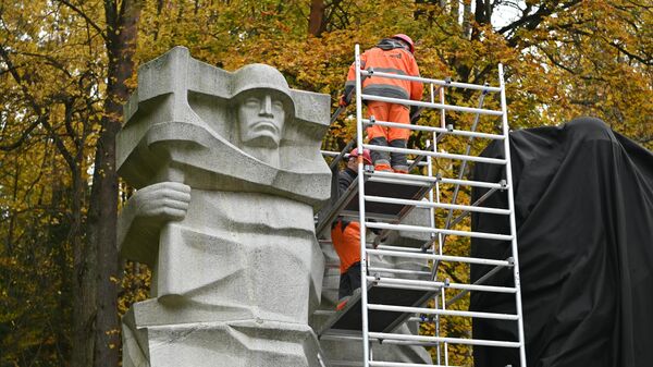 Рабочие закрывают черной тканью памятник советским воинам на Антакальнисском кладбище в Вильнюсе - Sputnik Литва