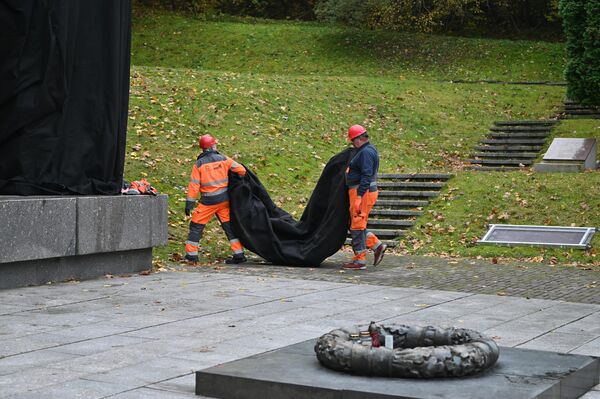 К обеду все шесть стел мемориала были уже обернуты в плотную черную агропленку. - Sputnik Литва
