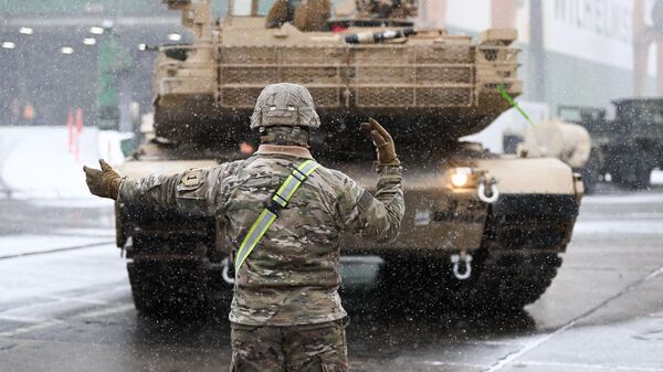 Солдат армии США указывает путь боевому танку M1A2 Abrams - Sputnik Литва