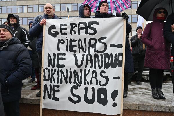 На фото: участники акции протеста держат в руках плакат с надписью &quot;Хорошее молоко — не вода, фермер — не собака&quot;. - Sputnik Литва