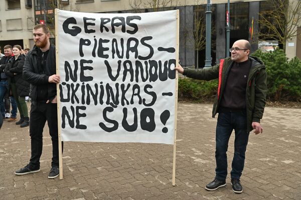 На фото: участники акции протеста держат в руках плакат с надписью &quot;Хорошее молоко — не вода, фермер — не собака&quot;. - Sputnik Литва