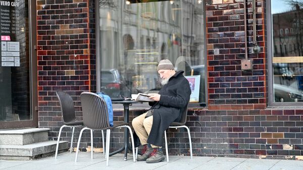 Пожилой мужчина за столиком в кафе в Вильнюсе - Sputnik Литва