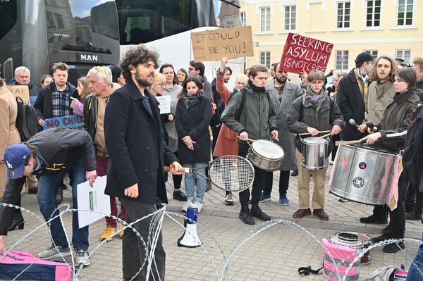 На фото: участники акции протеста в Вильнюсе держат плакаты: &quot;Поиск убежища — не преступление&quot;, &quot;Это мог быть ты&quot;. - Sputnik Литва