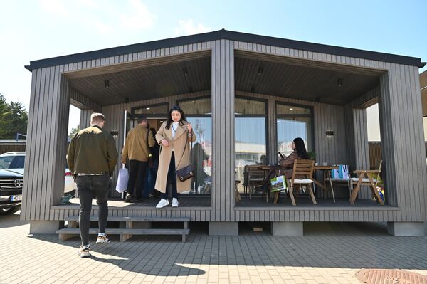 На фото: посетителям выставки осматривают дачный модульный домик. - Sputnik Литва