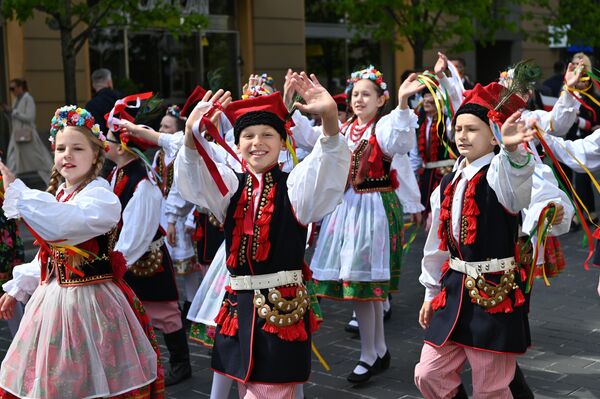 Многотысячная колонна людей, одетых  в национальные костюмы в бело-красных тонах, прошла под звуки польской музыки и песен. - Sputnik Литва