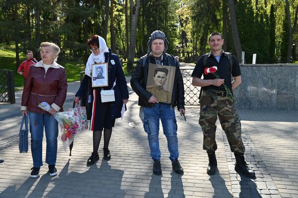 На фото: в День Победы жители Литвы посетили Антакальнисское кладбище, принеся с содой цветы и фотографии своих родственников, павших на фронте. - Sputnik Литва