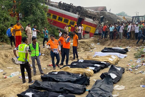 Спасатели рядом с телами погибших при столкновении поездов в Индии - Sputnik Литва