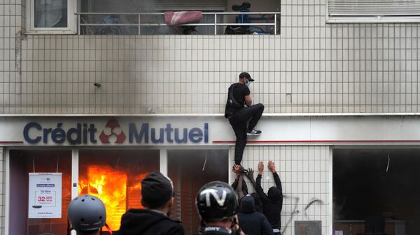 Протестующий взбирается на здание во время демонстрации в Нантере, Франция - Sputnik Литва