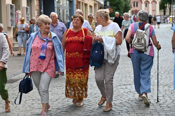 На улицах Старого города в выходные можно встретить множество туристических групп. - Sputnik Литва