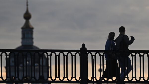 Люди идут по мосту через реку Яузу в Москве. - Sputnik Литва