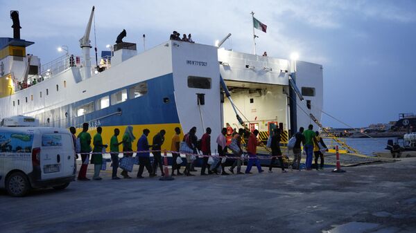Мигранты ждут посадки на корабль на итальянском острове Лампедуза, 18 сентября 2023 года - Sputnik Литва