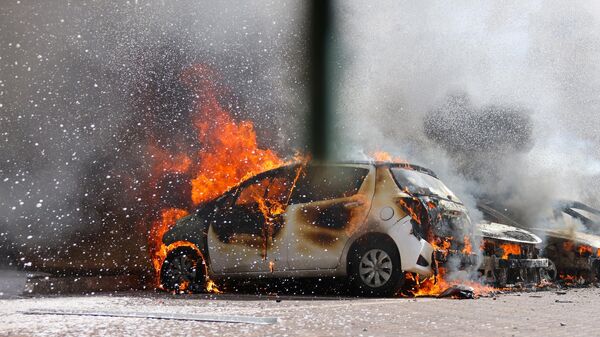 Горящий автомобиль в израильском Ашкелоне в результате атаки Палестины 7 октября 2023 года - Sputnik Литва