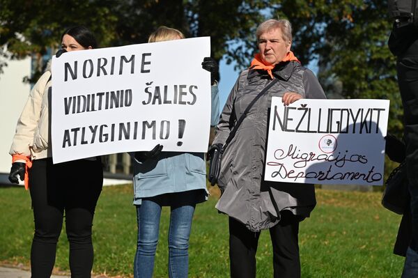 Надписи на плакатах: &quot;Хотим среднюю зарплату по стране&quot;, &quot;Не губите Департамент миграции&quot;. - Sputnik Литва