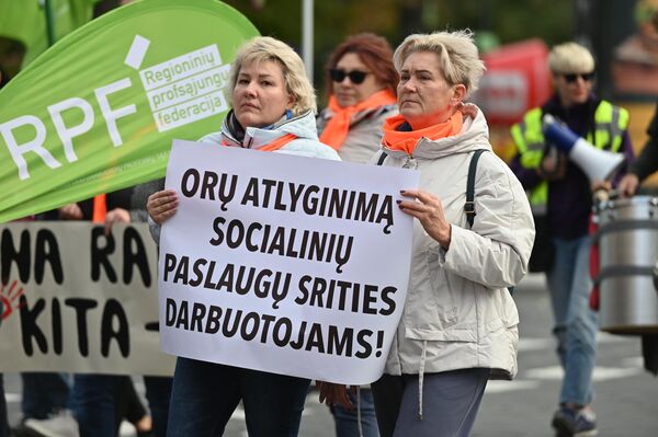 На фото: участницы митинга держат плакат с надписью: &quot;Достойную зарплату работникам сферы услуг&quot;. - Sputnik Литва