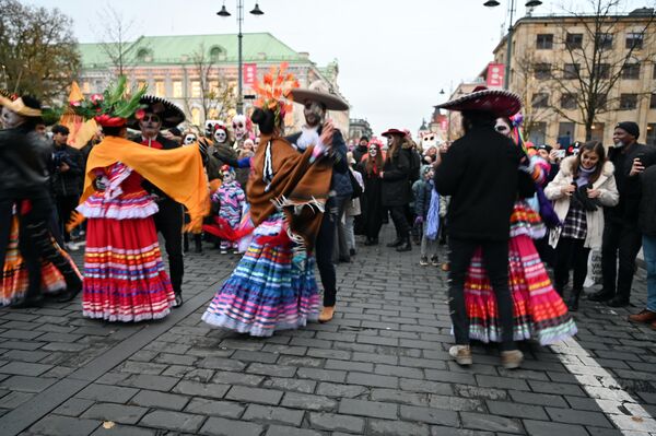Время от времени участники шествия останавливались и танцевали с прохожими сальсу под мексиканские ритмы. - Sputnik Литва