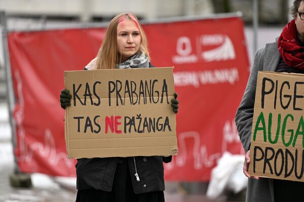 На фото: участница акции держит плакат с надписью: &quot;Что роскошь — то не прогресс&quot;. - Sputnik Литва
