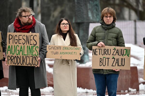 На фото: участники акции держат плакаты с надписями: &quot;Более дешевой растительной продукции&quot;, &quot;Жить экологично должно быть выгодно&quot;, &quot;Нет зеленых, чтобы быть зеленым&quot;. - Sputnik Литва