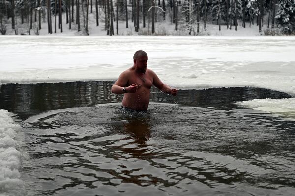 На фото: мужчина окунается в прорубь на Крещение. - Sputnik Литва