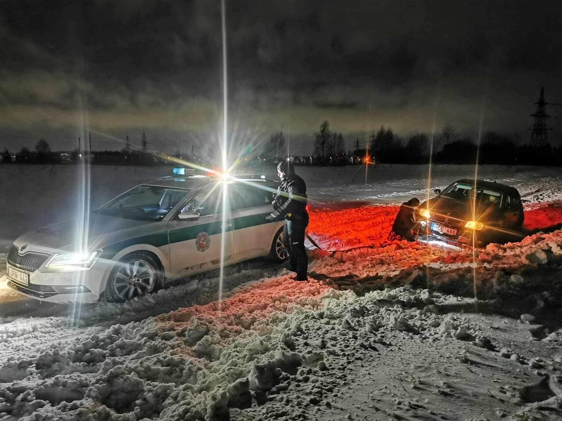 Литовские полицейские вытаскивают из сугроба легковую машину - Sputnik Литва, 1920, 22.01.2024
