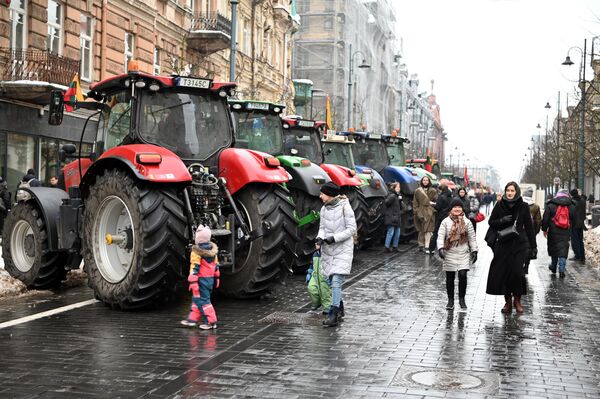 Жители Вильнюса спокойно реагируют на тракторы в городе, многие фотографируются на их фоне. - Sputnik Литва