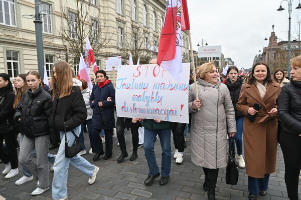 На фото: участники акции держат плакат с надписью: &quot;СТОП дискриминации школ нацменьшинств&quot;. - Sputnik Литва
