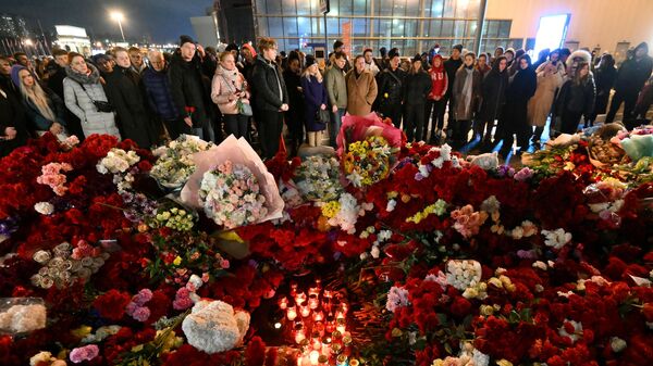 Люди у стихийного мемориала возле подмосковного Крокус Сити Холла в память о жертвах теракта - Sputnik Литва