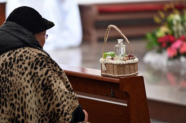 На фото: женщина во время службы в соборе имени Петра и Павла в Вильнюсе. - Sputnik Литва