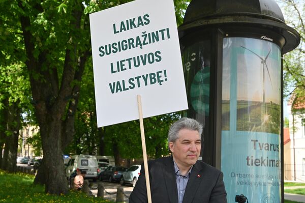 Активисты считают, что проект Rail Baltica является важным, но не должен осуществляться за счет жителей Паневежского района. На фото: участник пикета держит плакат с надписью: 