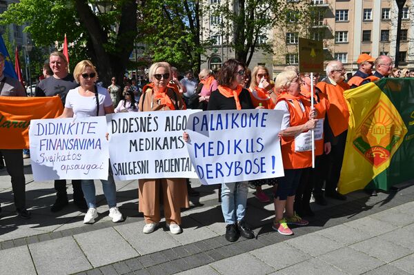 Участницы шествия с плакатами &quot;Увеличивайте финансирование здравоохранения!&quot;, &quot;Больше зарплата у медиков - пациенты в большей безопасности&quot;, &quot;Поддерживаем медиков в переговорах&quot;. - Sputnik Литва