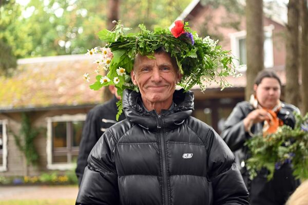 На фото: мужчина с венком из цветов и трав. - Sputnik Литва