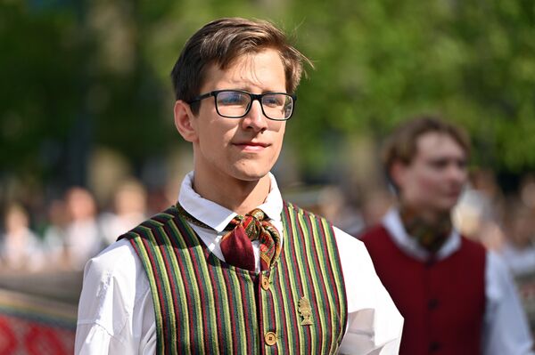 На фото: участник шествия &quot;Праздника песен&quot; в Вильнюсе. - Sputnik Литва