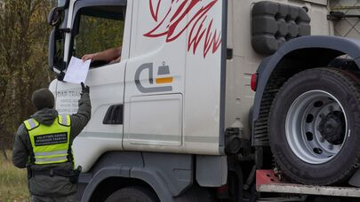 Литовский пограничник проверяет документы у водителя фуры, архивное фото