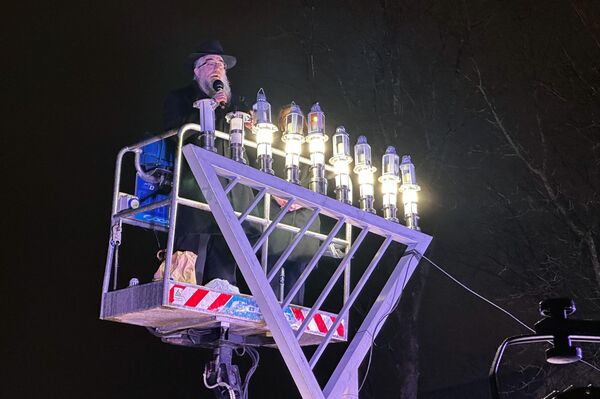 На фото: ханукальные свечи зажигает раввин Шалом Бер Крински. - Sputnik Литва