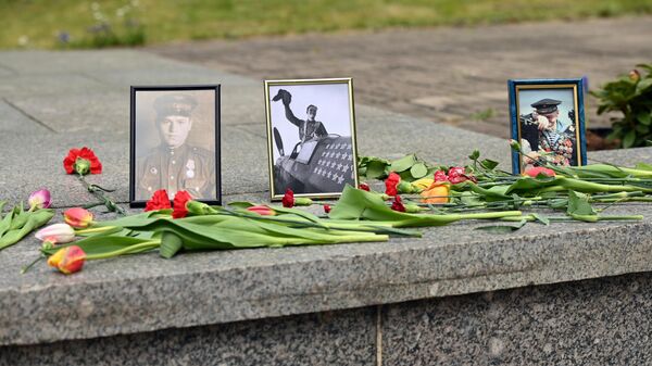Жители Литвы в День Победы принесли цветы и фотографии к снесенному мемориалу на Антакальнисском кладбище в Вильнюсе - Sputnik Литва