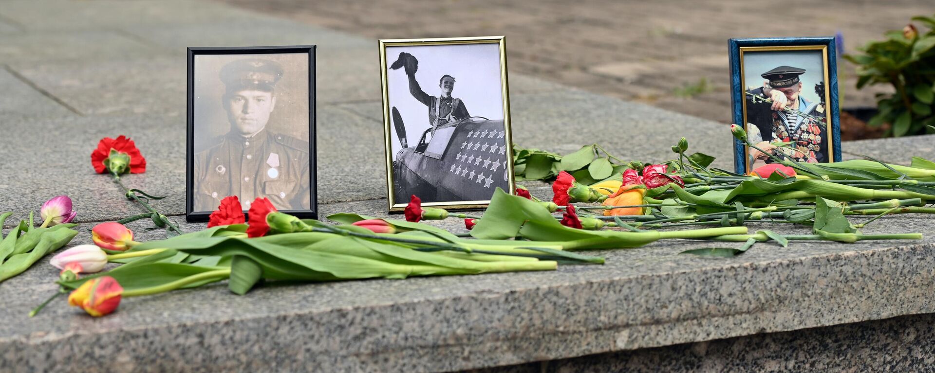 Жители Литвы в День Победы принесли цветы и фотографии к снесенному мемориалу на Антакальнисском кладбище в Вильнюсе - Sputnik Литва, 1920, 09.05.2025