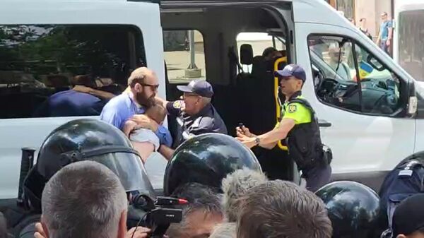Полиция задерживает мужчину с ребенком на руках на акции против поддержки ЛГБТ* в Кишиневе - Sputnik Литва