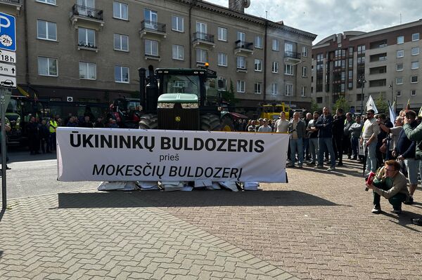 На фото: прикрепленный к трактору плакат с надписью: "Бульдозер фермеров против налогового бульдозера" На фото: прикрепленный к трактору плакат с надписью: "Бульдозер фермеров против налогового бульдозера" - Sputnik Литва